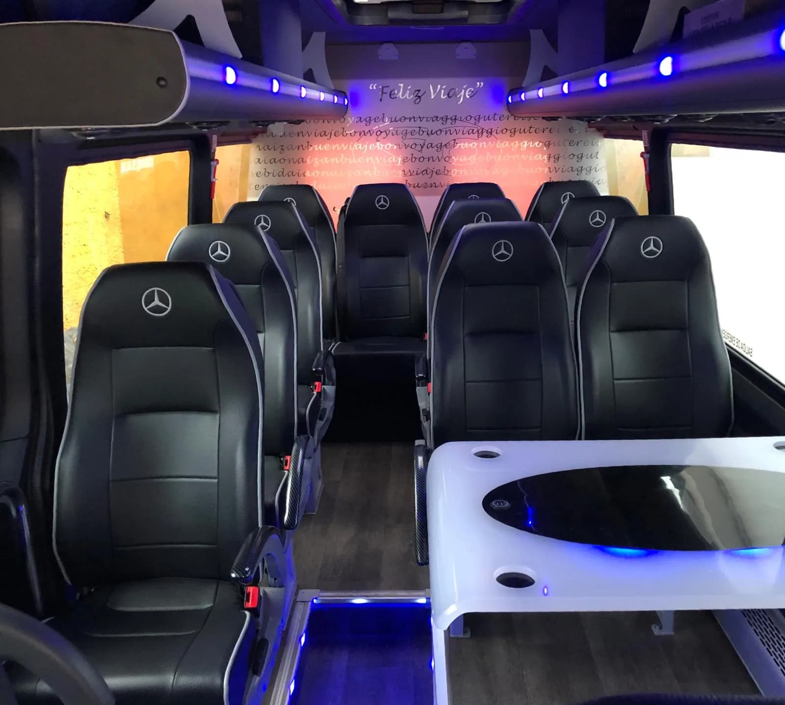 Interior of a 14-seat luxury minibus with leather seats and blue interior lighting